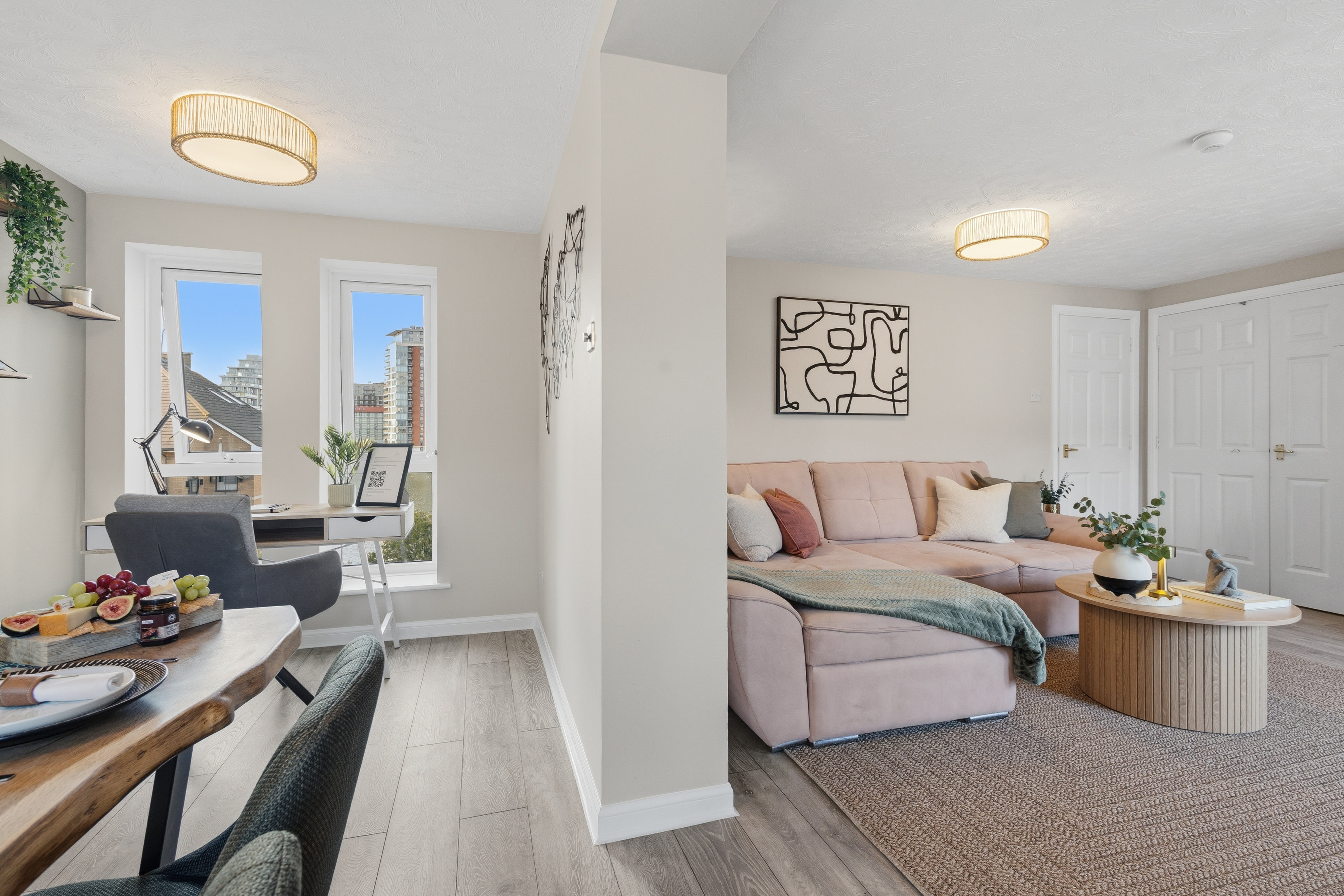Bright city-view lounge with workspace, dining nook, and cozy modern style