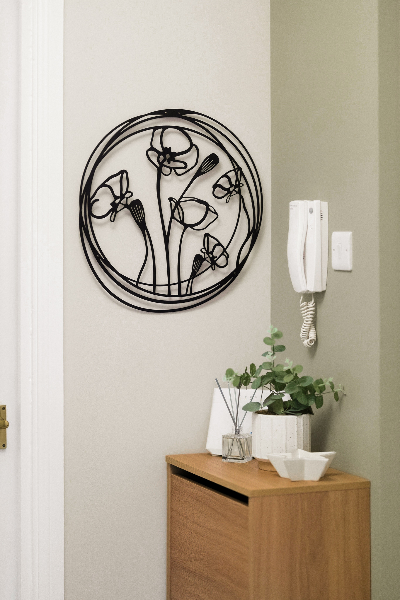 Stylish entryway with floral wall art, console table, and guest intercom