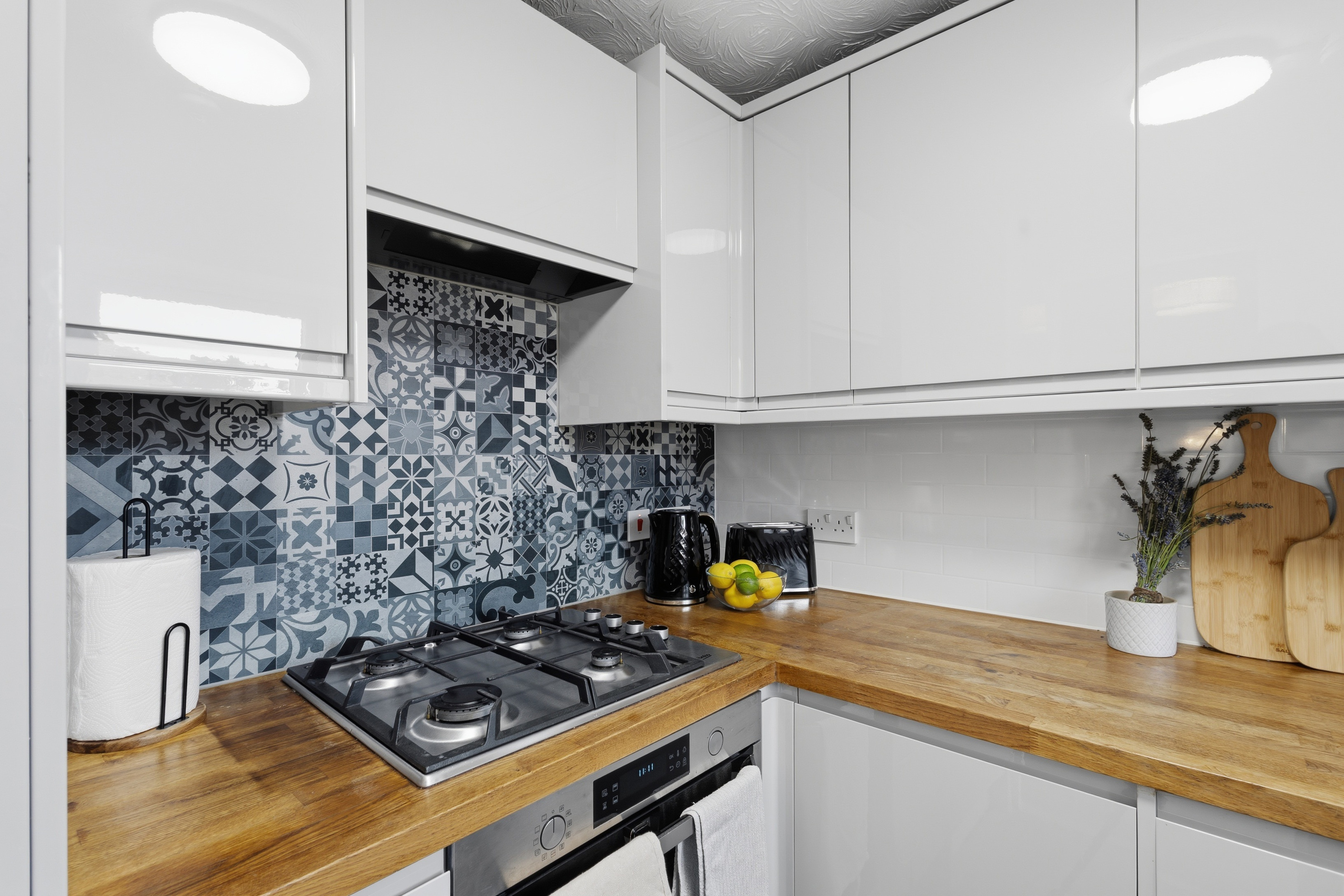 Stylish modern kitchen with wood counters and patterned tile backsplash