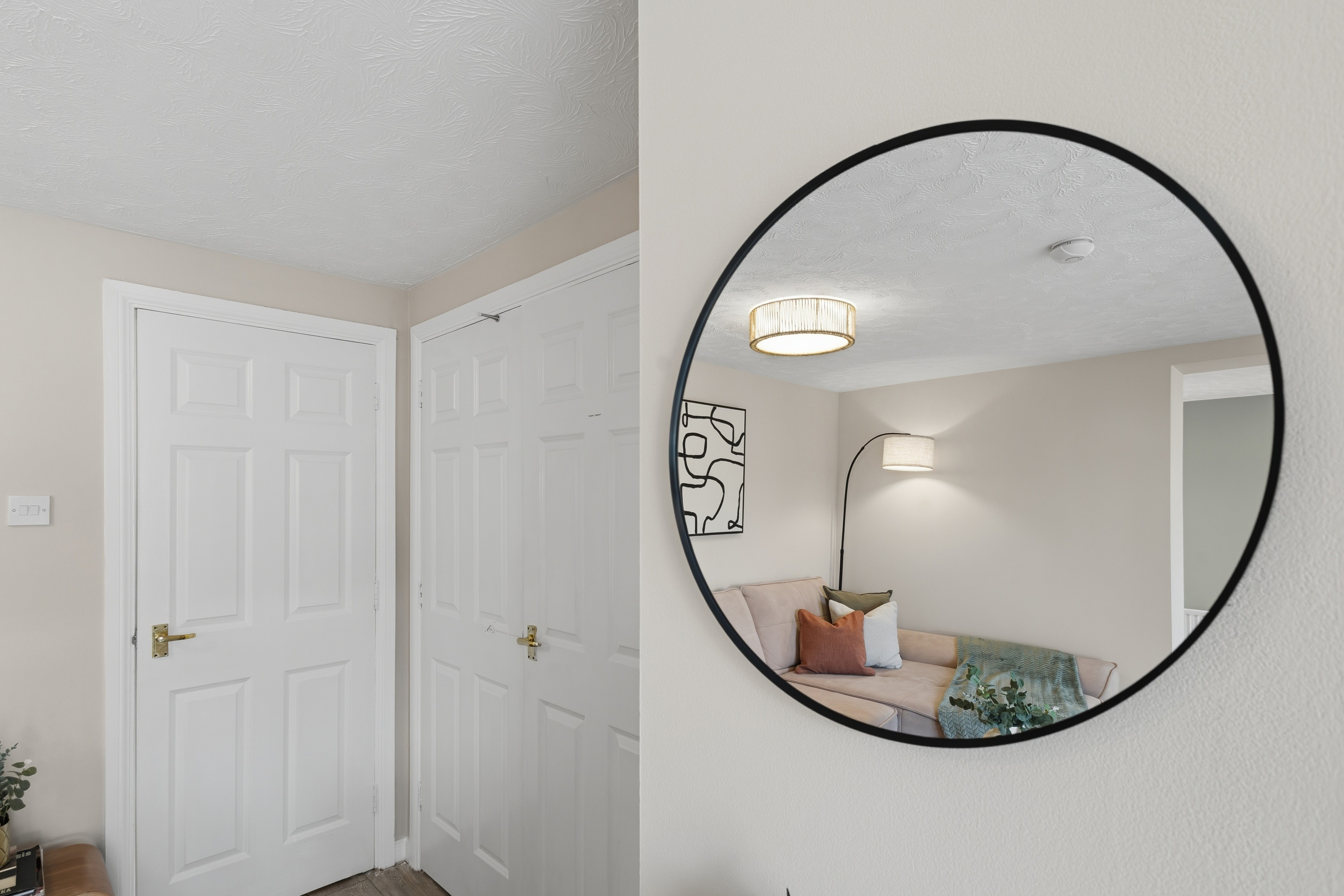 Bright entryway with statement mirror and glimpse of cozy lounge