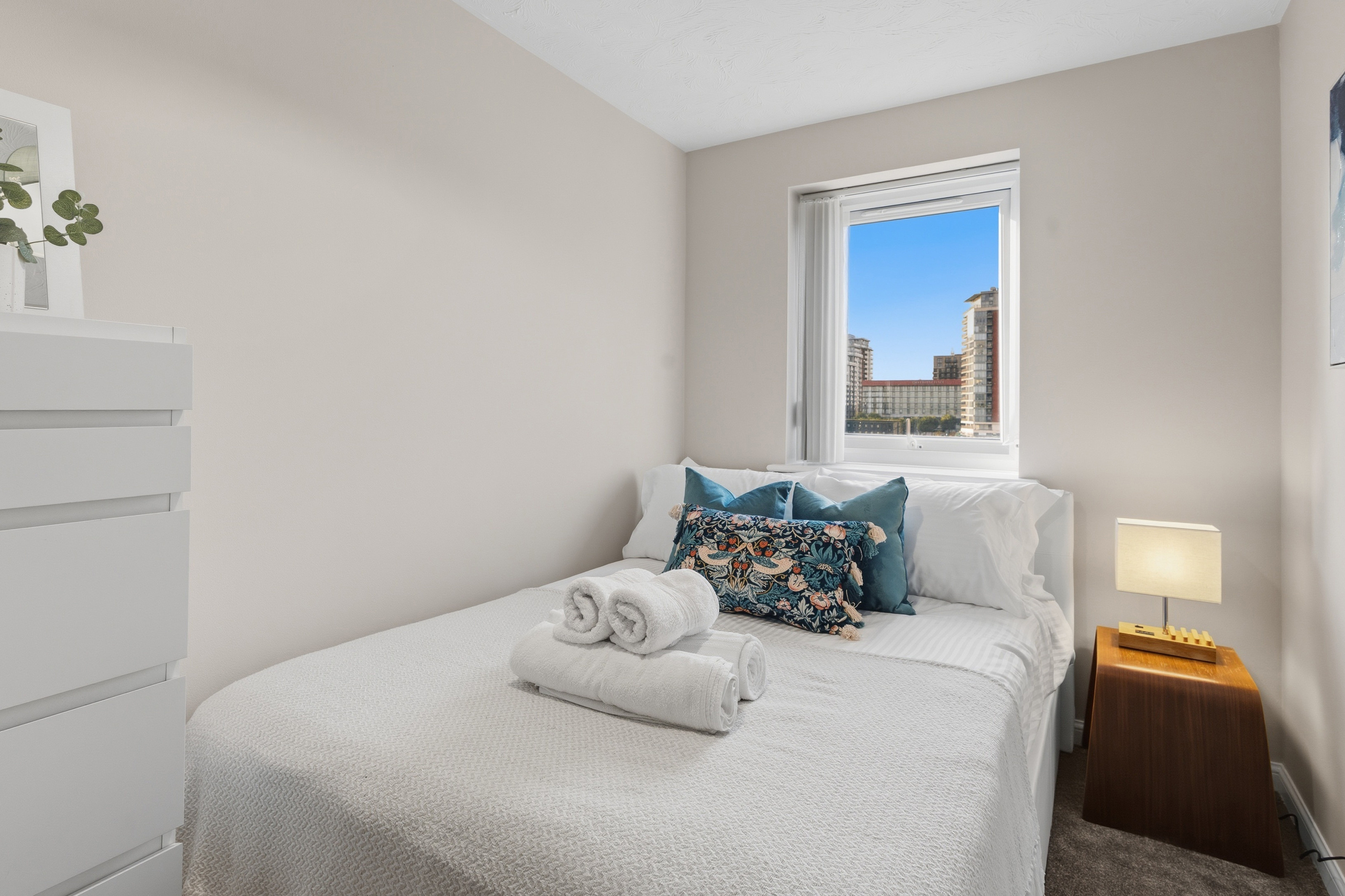 Bright, cozy bedroom with city views and fresh hotel-style touches