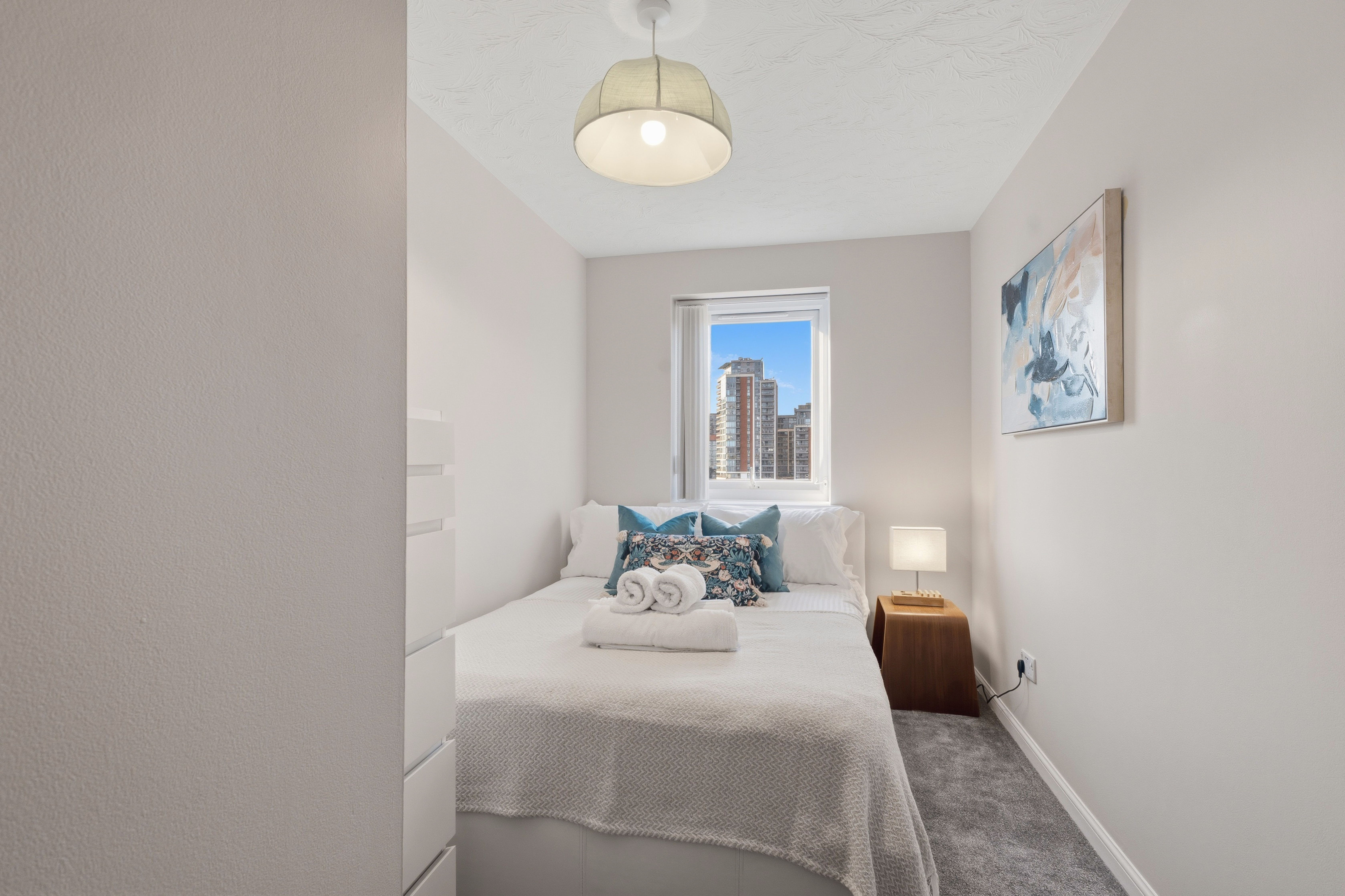 Cozy city-view bedroom with soft lighting and crisp, inviting decor