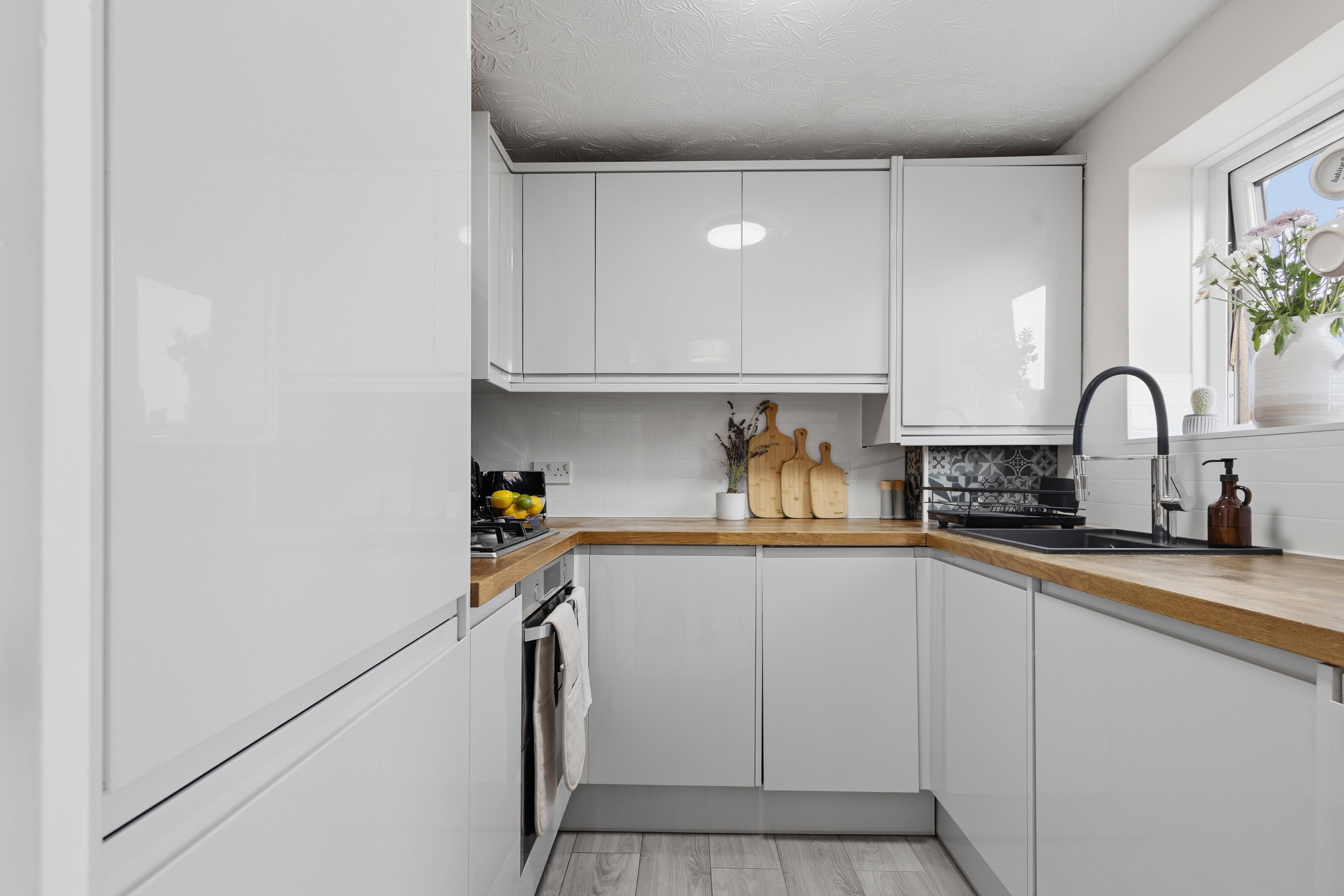Bright modern kitchen with sleek cabinets and warm wood countertops
