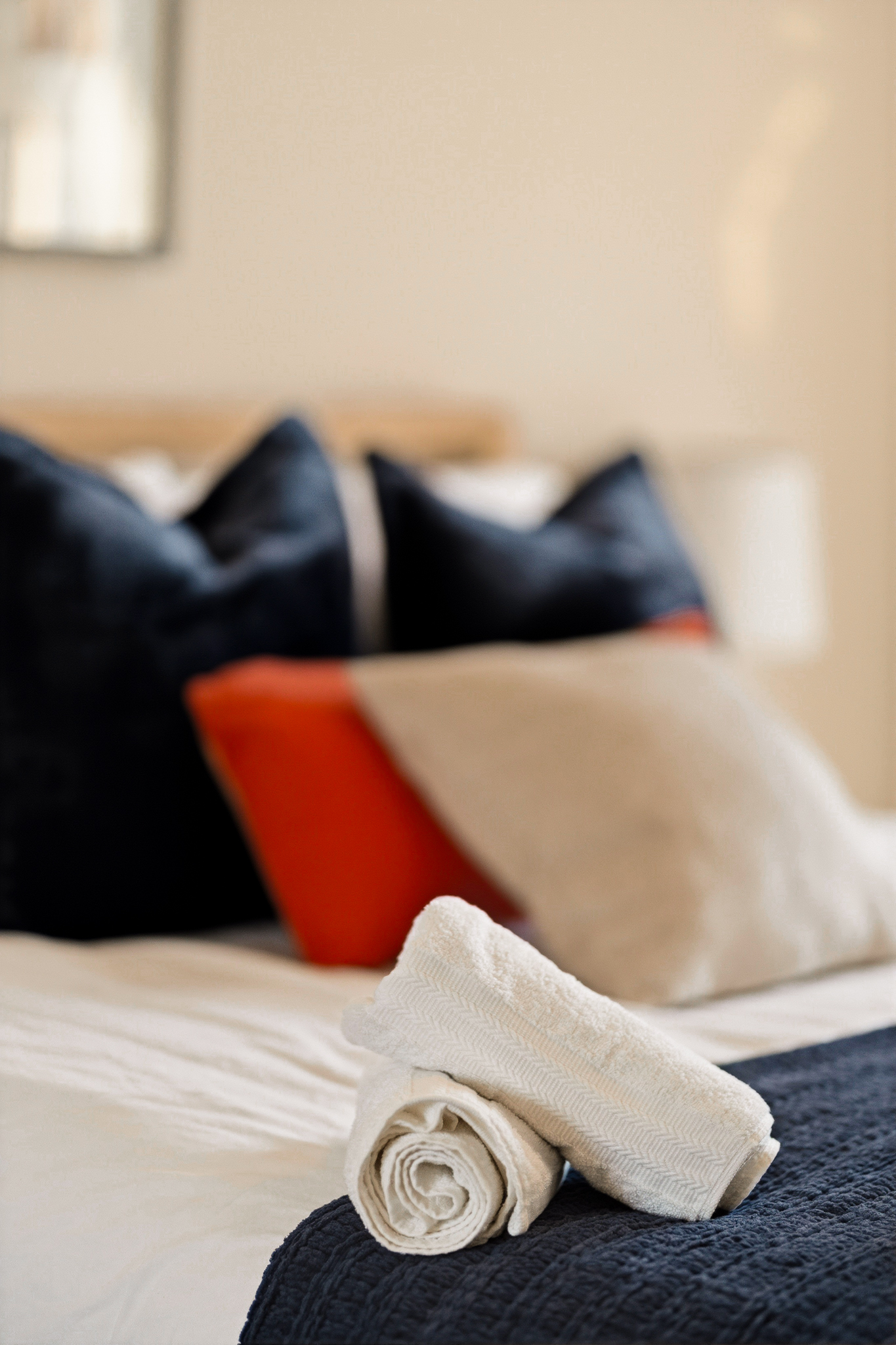 Cozy, hotel-inspired bedroom with fresh towels and stylish accent pillows