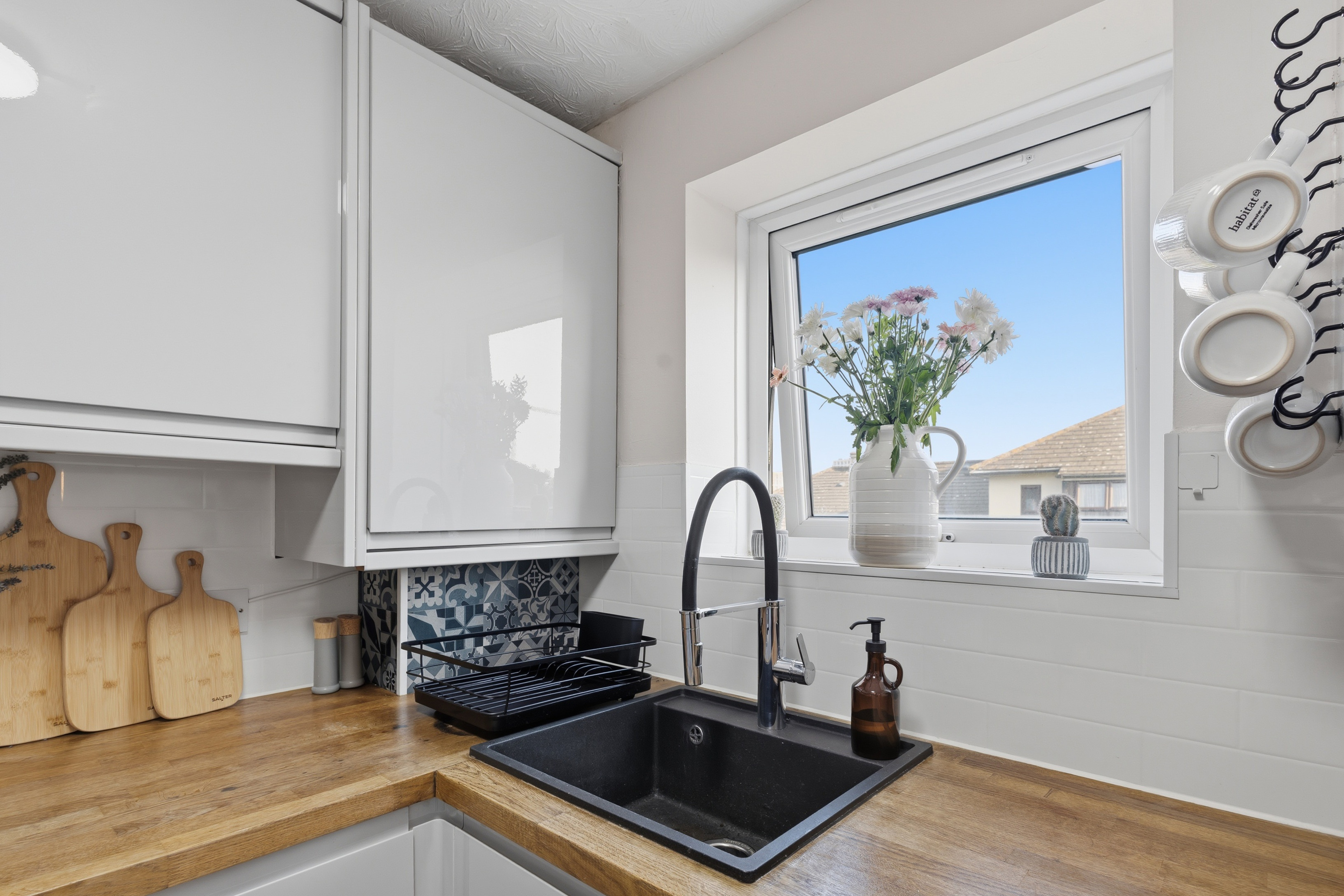 Bright modern kitchen with natural light, wood counters, and stylish finishes