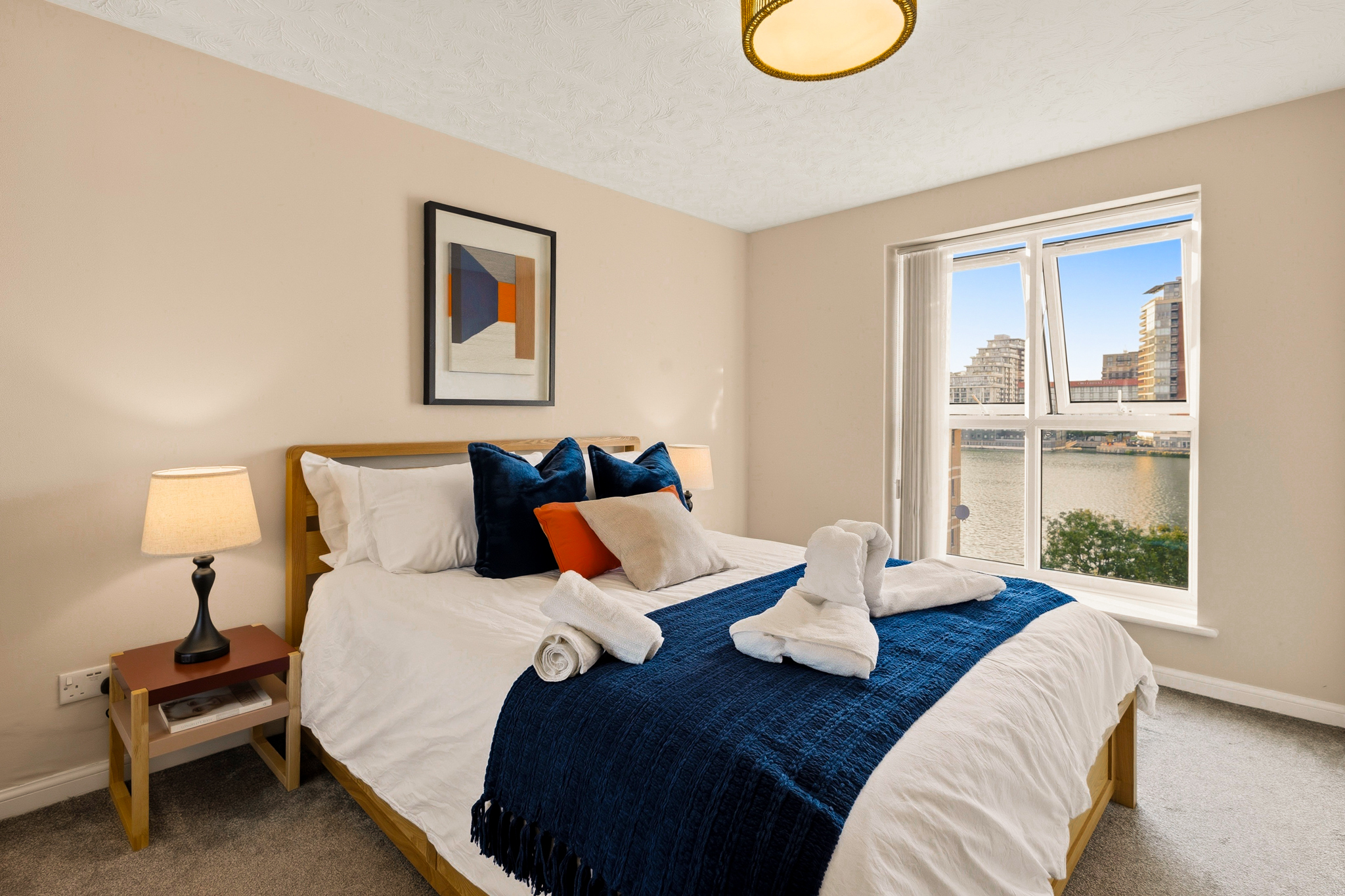 Cozy waterfront bedroom with bright natural light and stylish decor
