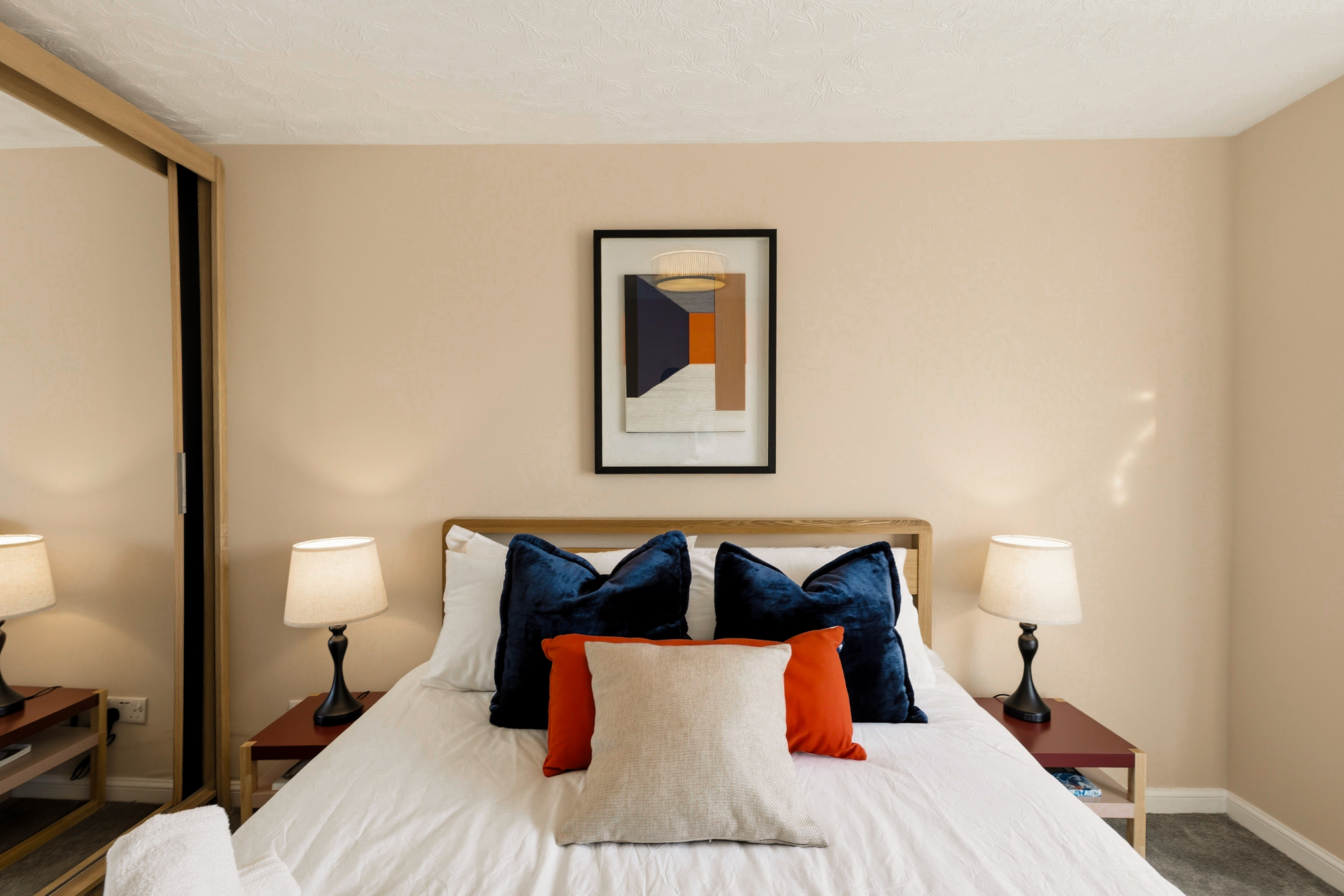 Cozy, stylish bedroom with plush pillows and warm bedside lighting