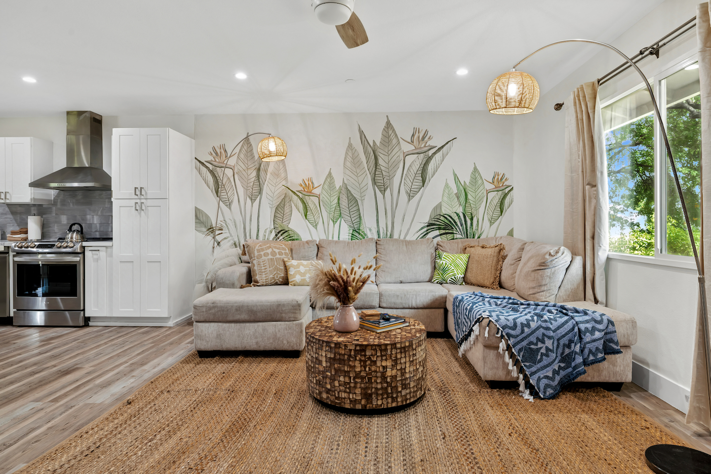 Bright tropical living room with plush sectional and garden views