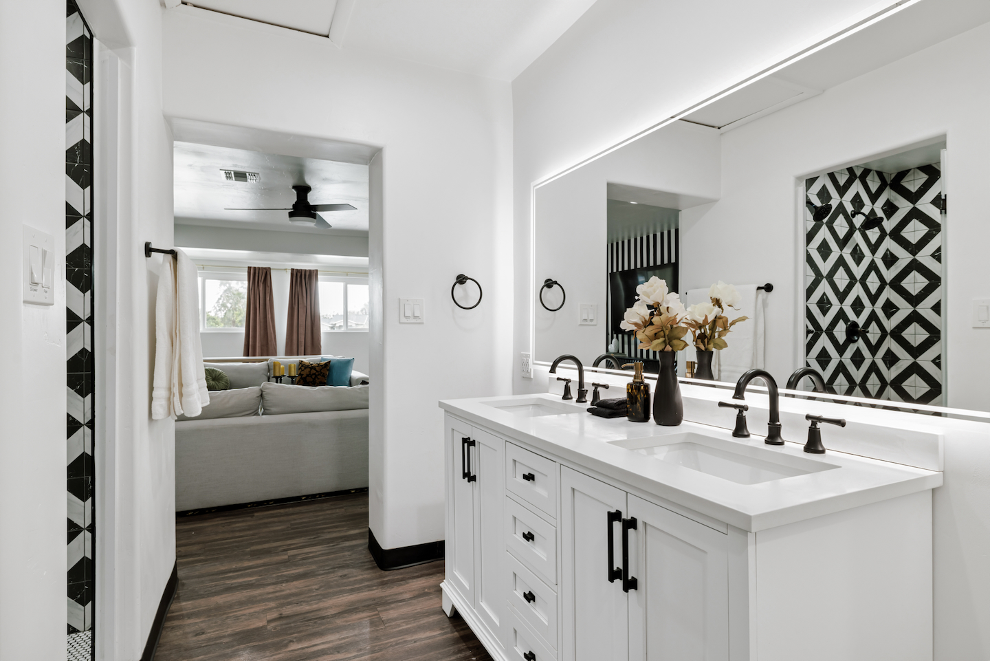 Bathroom off the living room with double vanity and backlit mirror