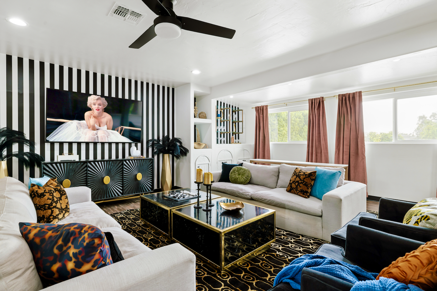 Living room with striped accent wall, sectional seating and 70" Smart TV