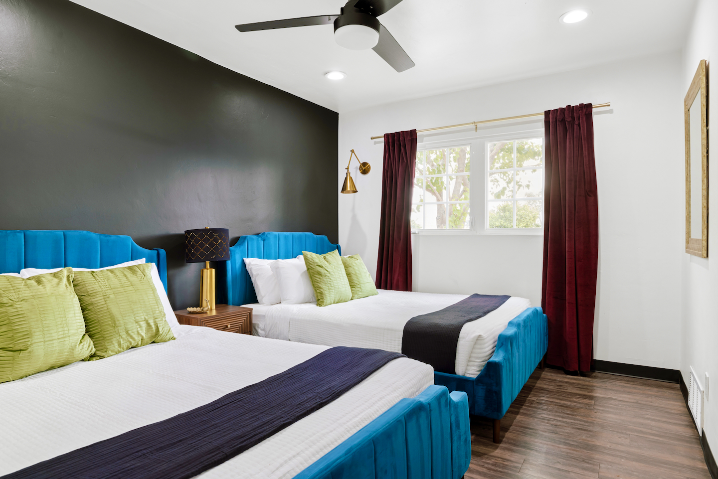 Bedroom with two queen beds and teal velvet headboards