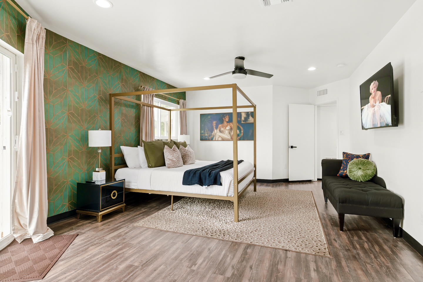 Primary suite with king canopy bed and velvet sofa