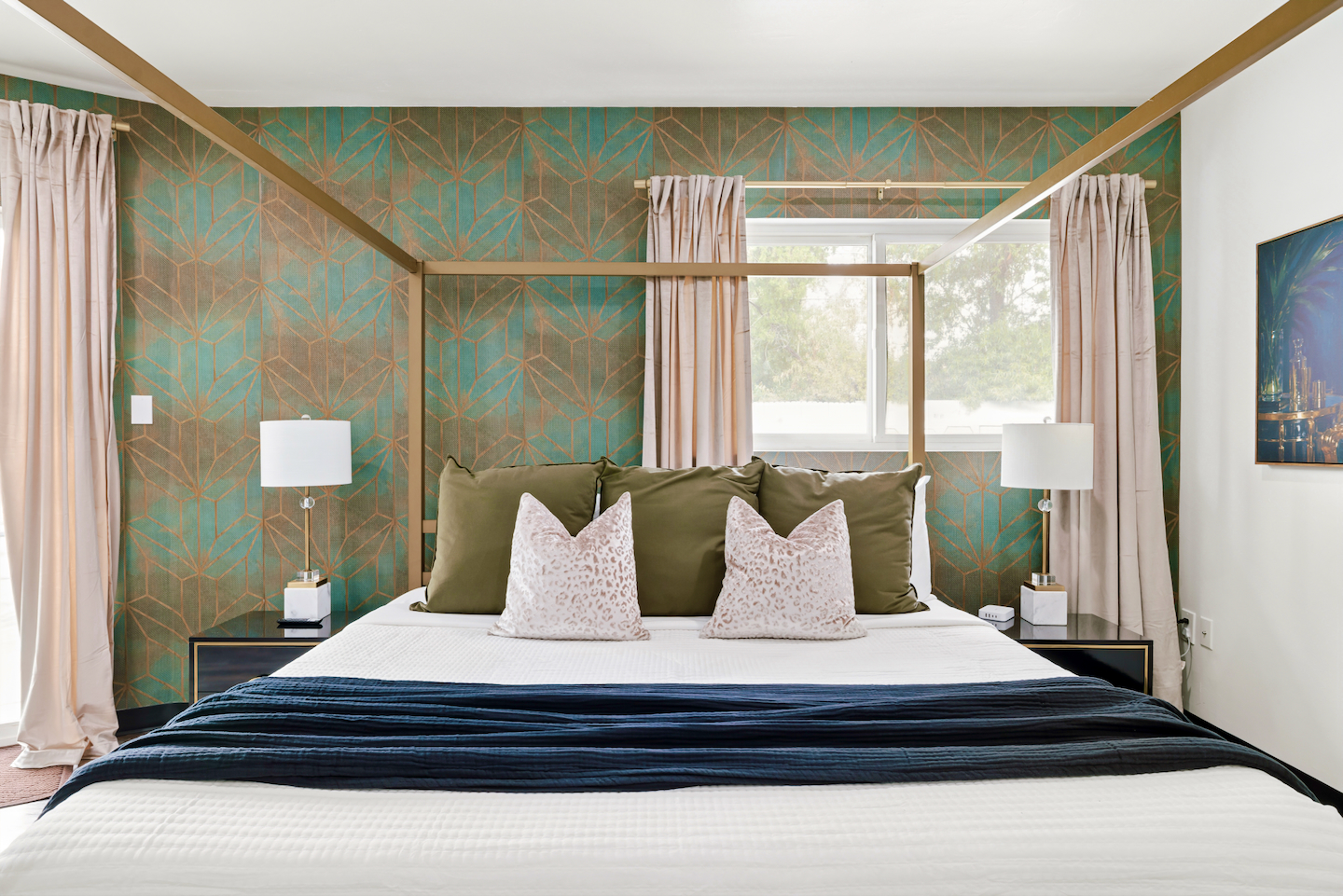 Primary suite with king canopy bed and accent wallpaper