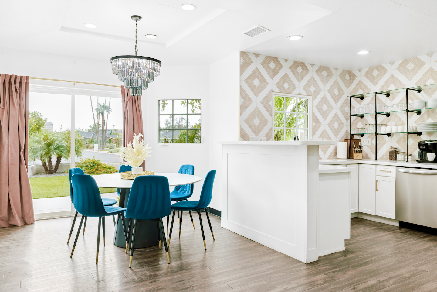 Round dining table with crystal chandelier next to the kitchen