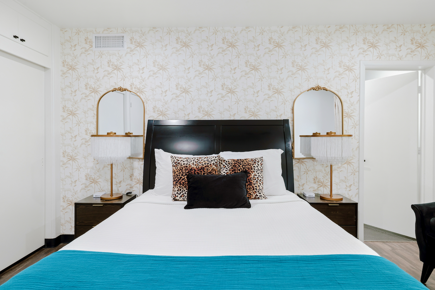 Queen bedroom with black headboard and gold mirrors