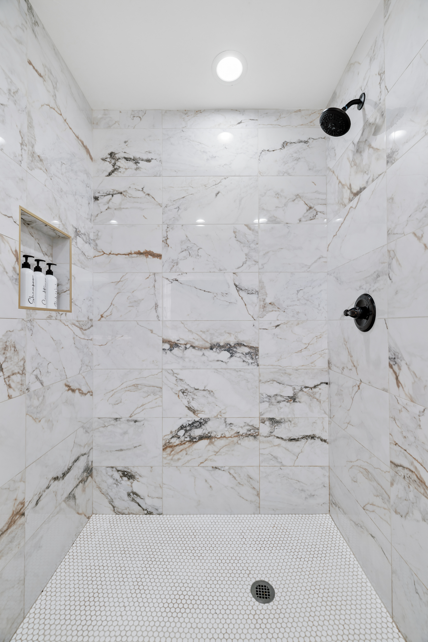 Marble tile walk-in shower with built-in niche