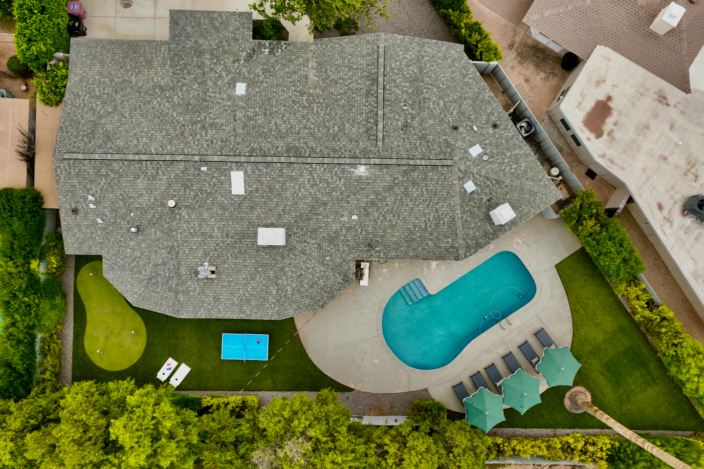 Aerial view of the home with pool, loungers and ping-pong table