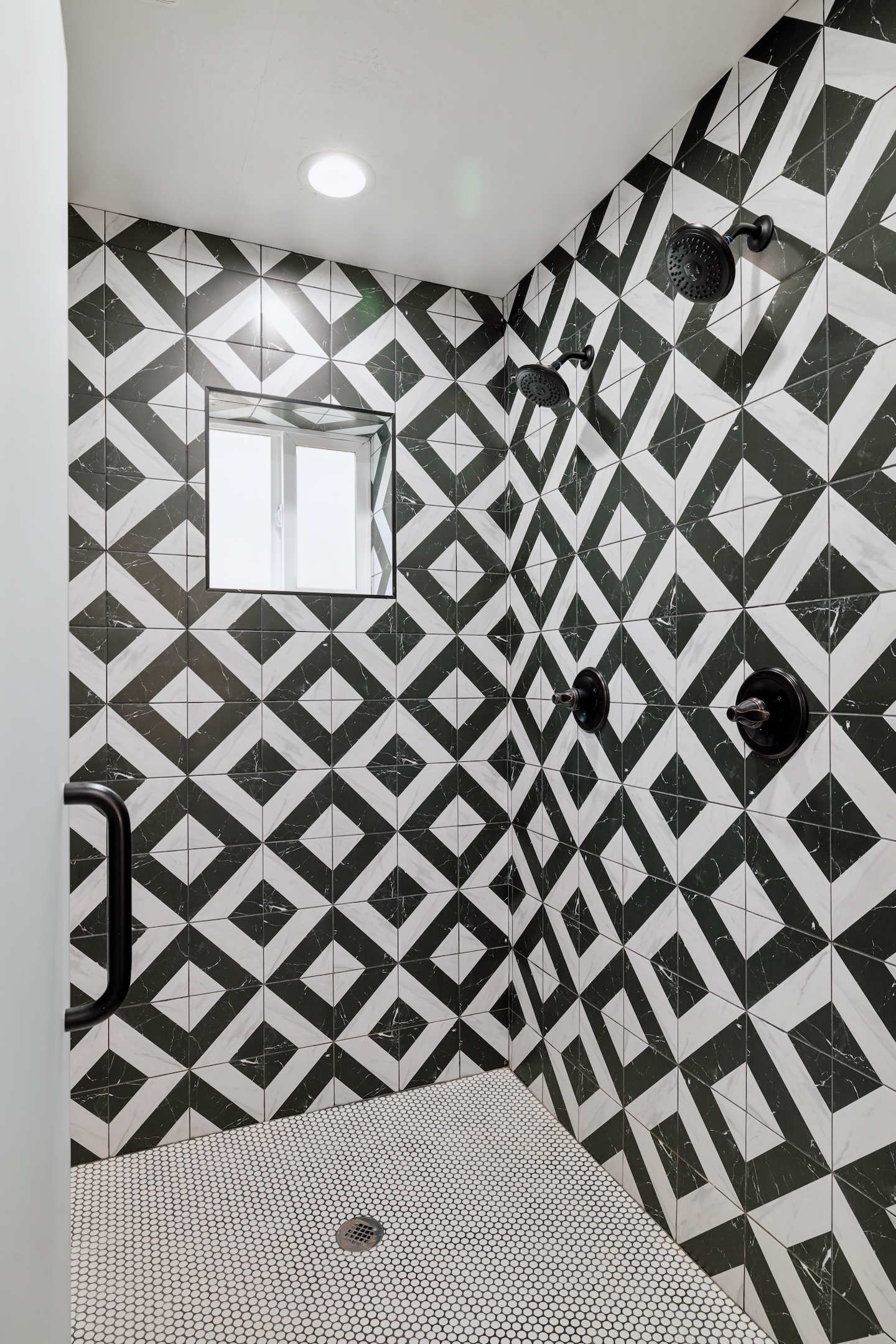 Black and white tile walk-in shower with two shower heads