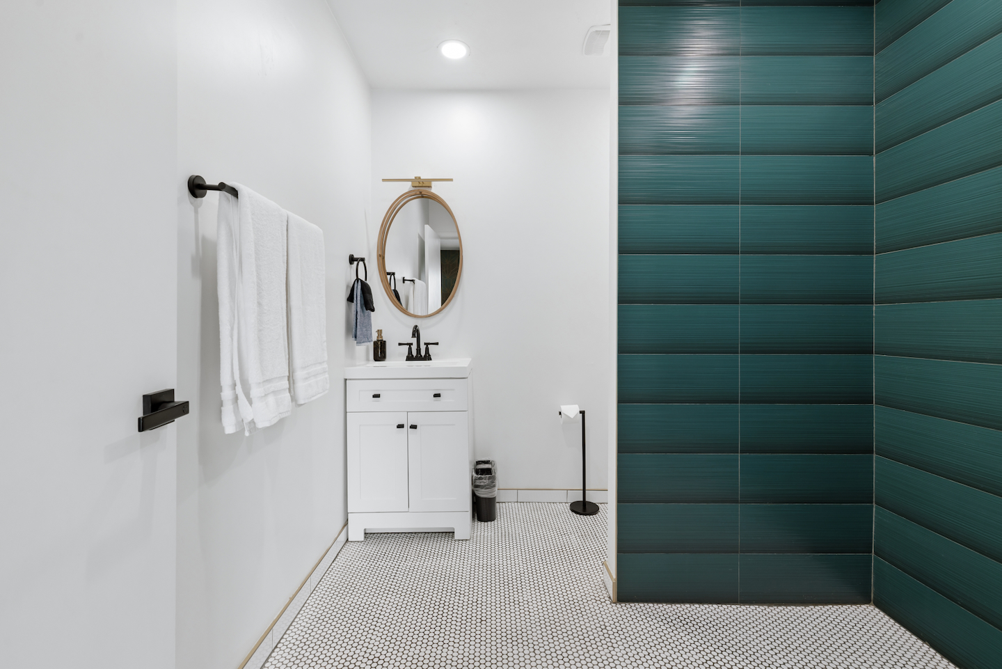 Bathroom with single vanity and teal tile walk-in shower