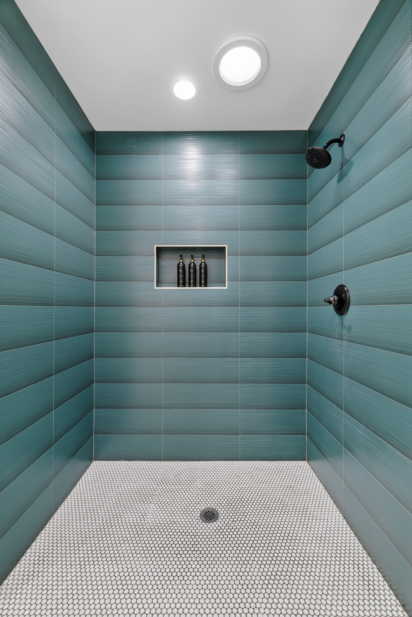 Teal tile walk-in shower with built-in niche