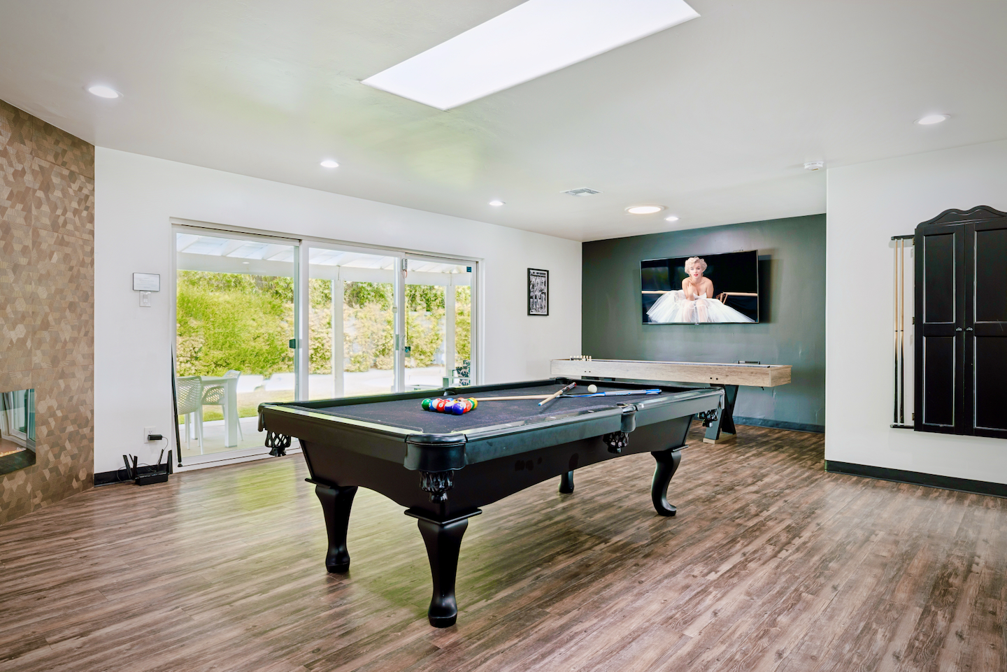 Game room with pool table, 70" Smart TV and sliding doors to the backyard