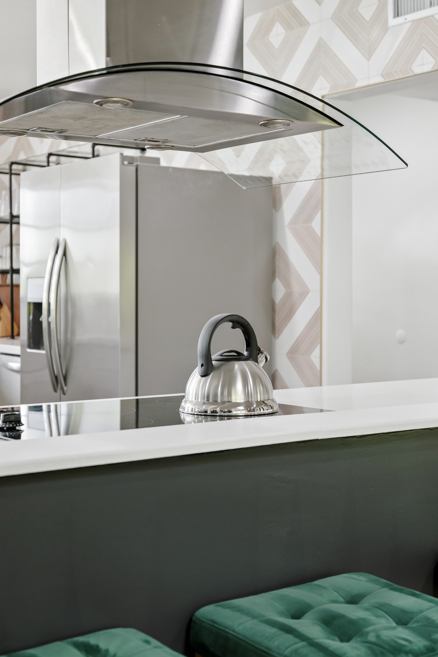 Kitchen with tea kettle, glass range hood and stainless refrigerator