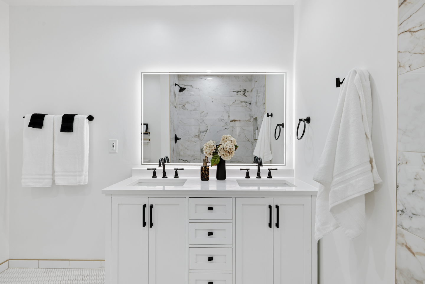 Bathroom with double vanity and backlit mirror