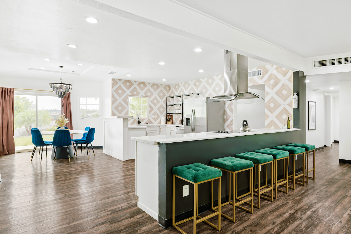 Kitchen island with velvet bar stools and dining table beyond