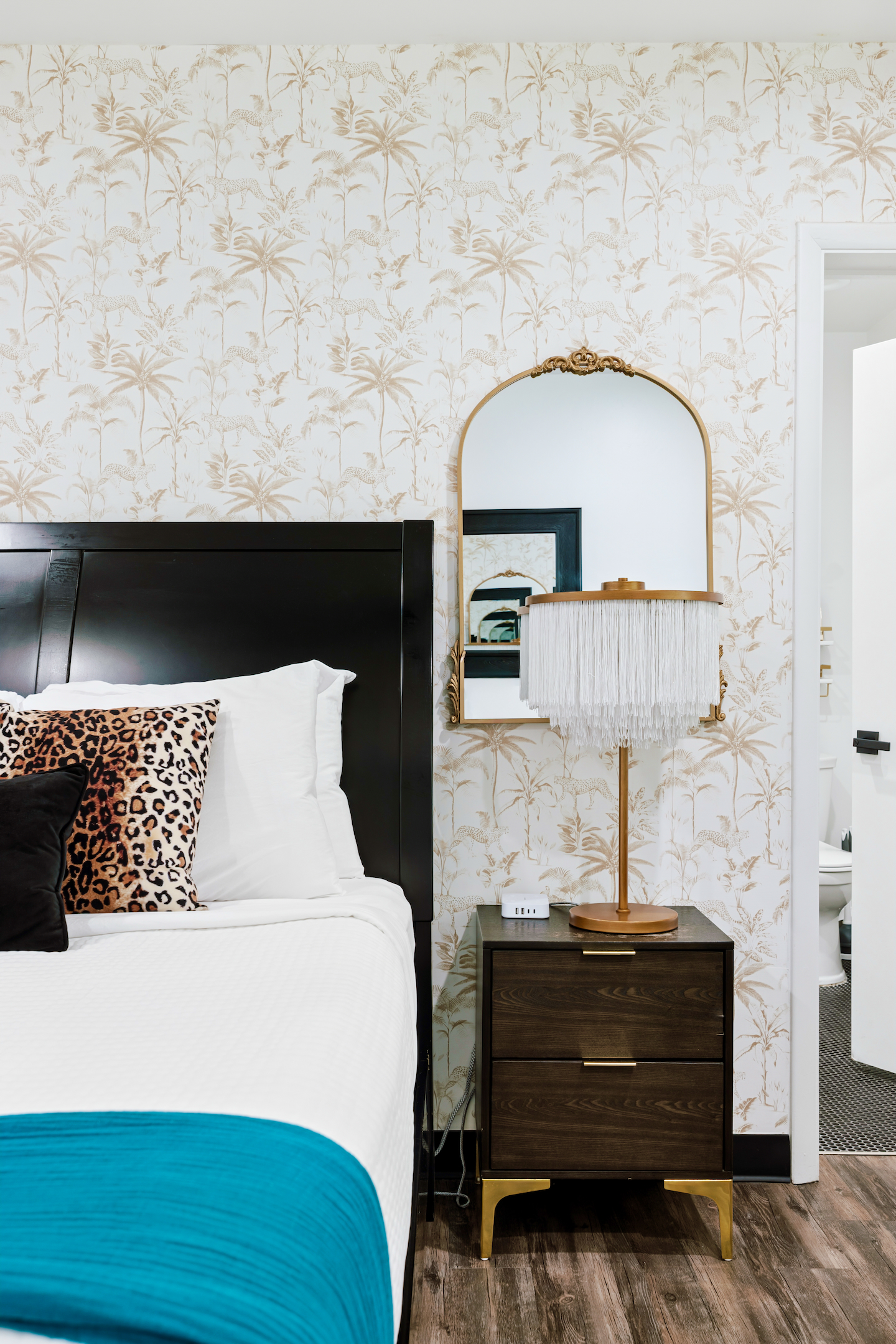 Queen bedroom nightstand with fringe lamp and gold mirror