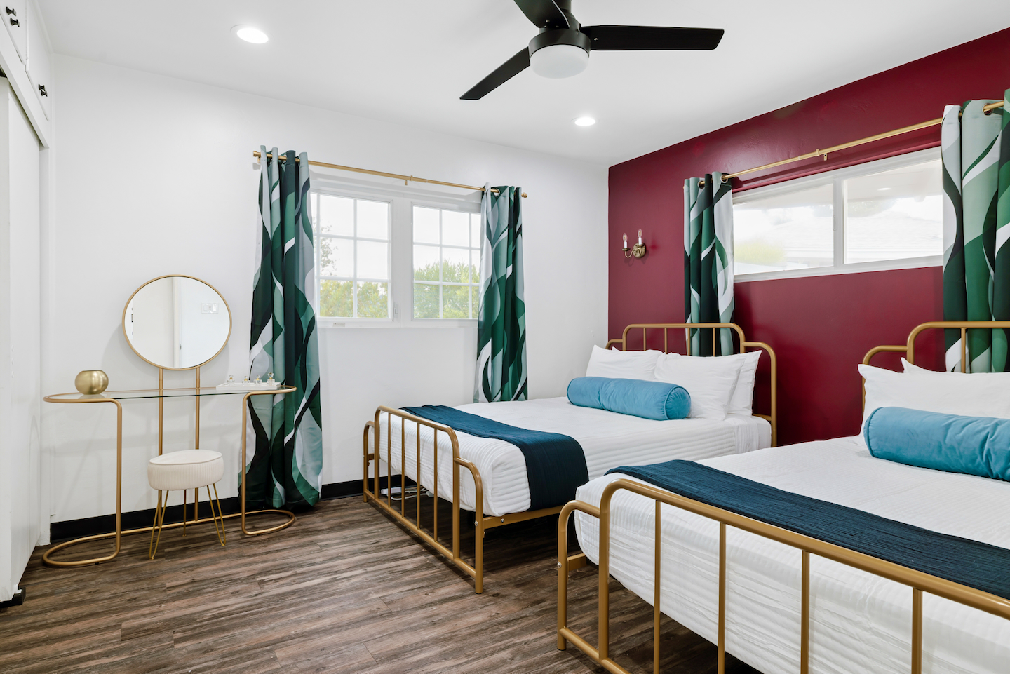 Bedroom with two queen beds, gold bed frames and vanity
