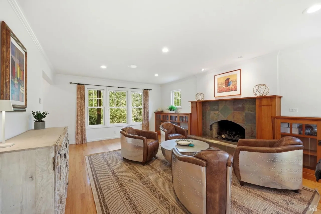 Bright living room with cozy fireplace and serene window views
