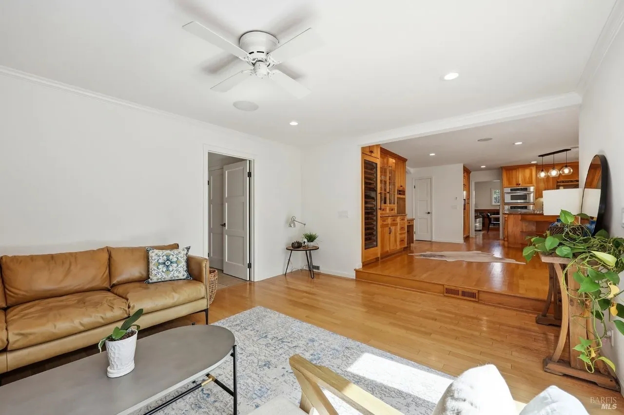 Bright living room with hardwood floors and open kitchen flow