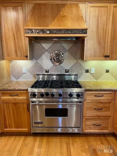 Chef-style kitchen with premium gas range and custom wood cabinetry