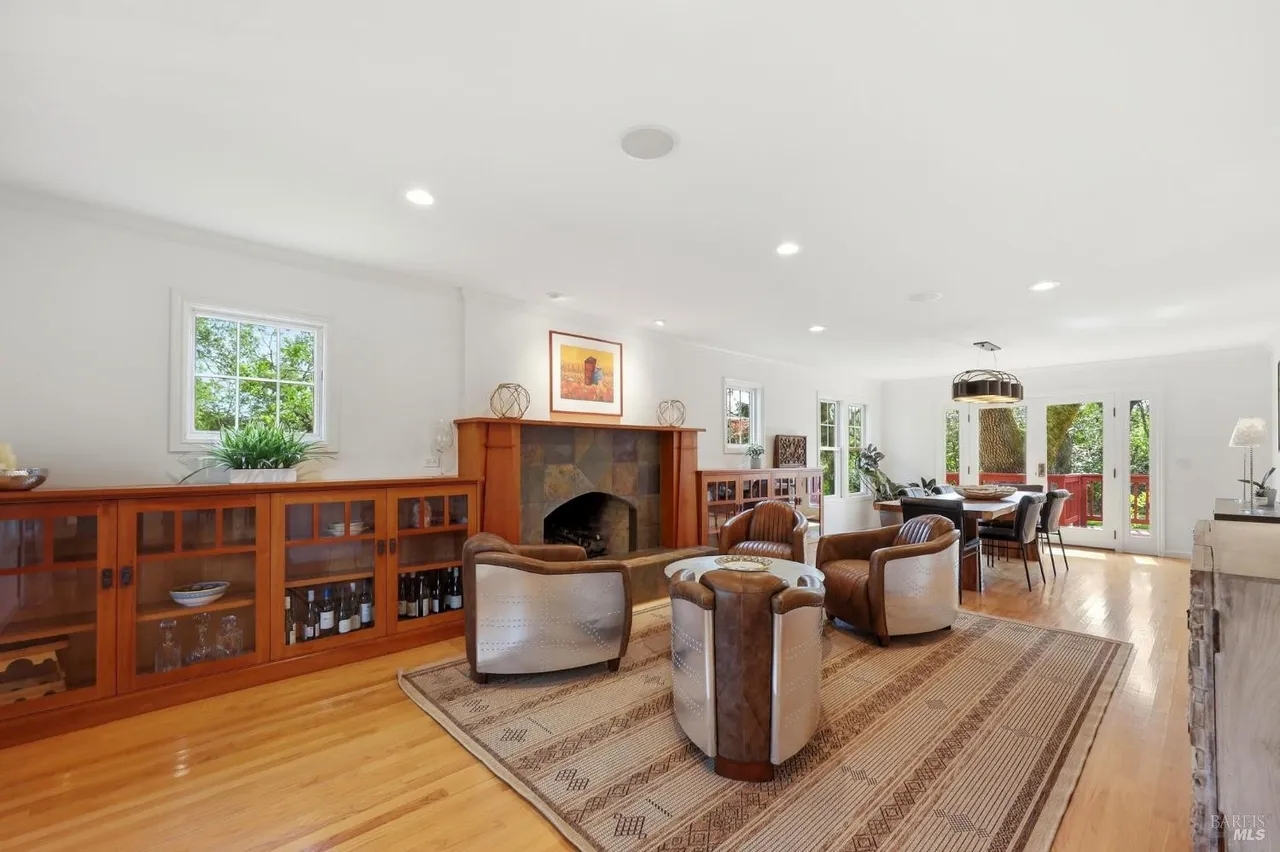 Bright open living space with fireplace, built-ins, and deck access
