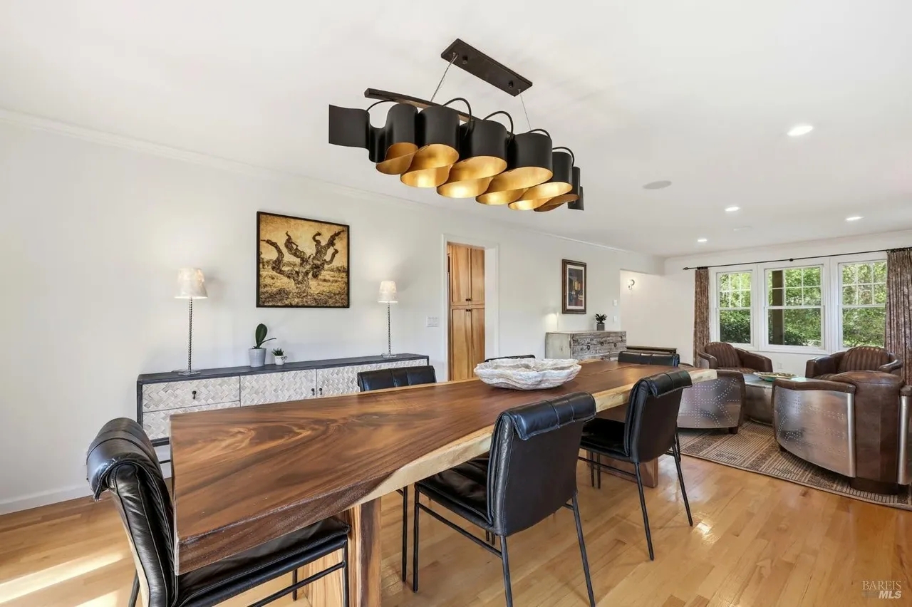 Bright open dining and living space with designer lighting and natural light