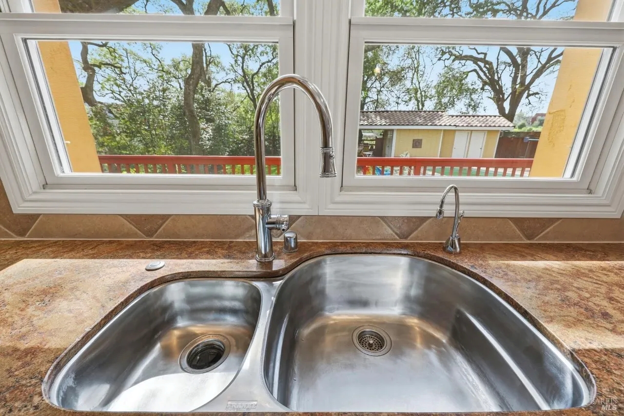 Bright kitchen sink with treetop views and abundant natural light
