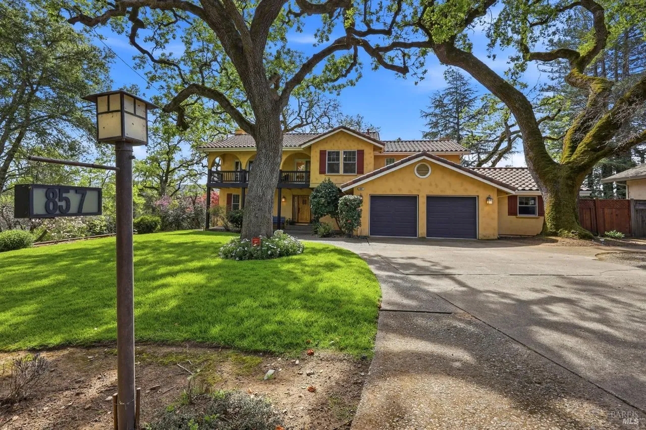 Charming tree-lined home with lush lawn, private drive, and great curb appeal