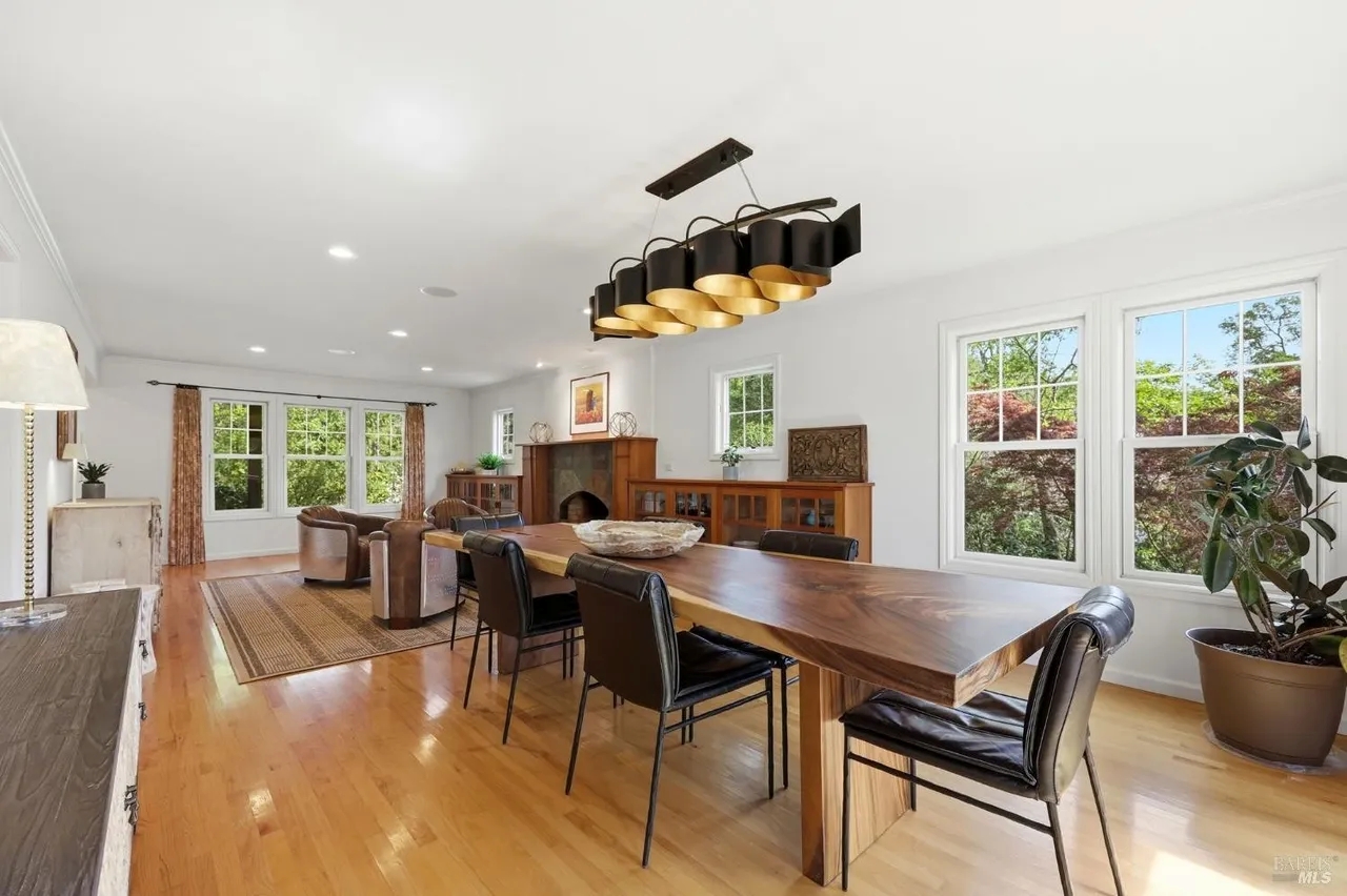 Bright open dining and living space with fireplace and garden views