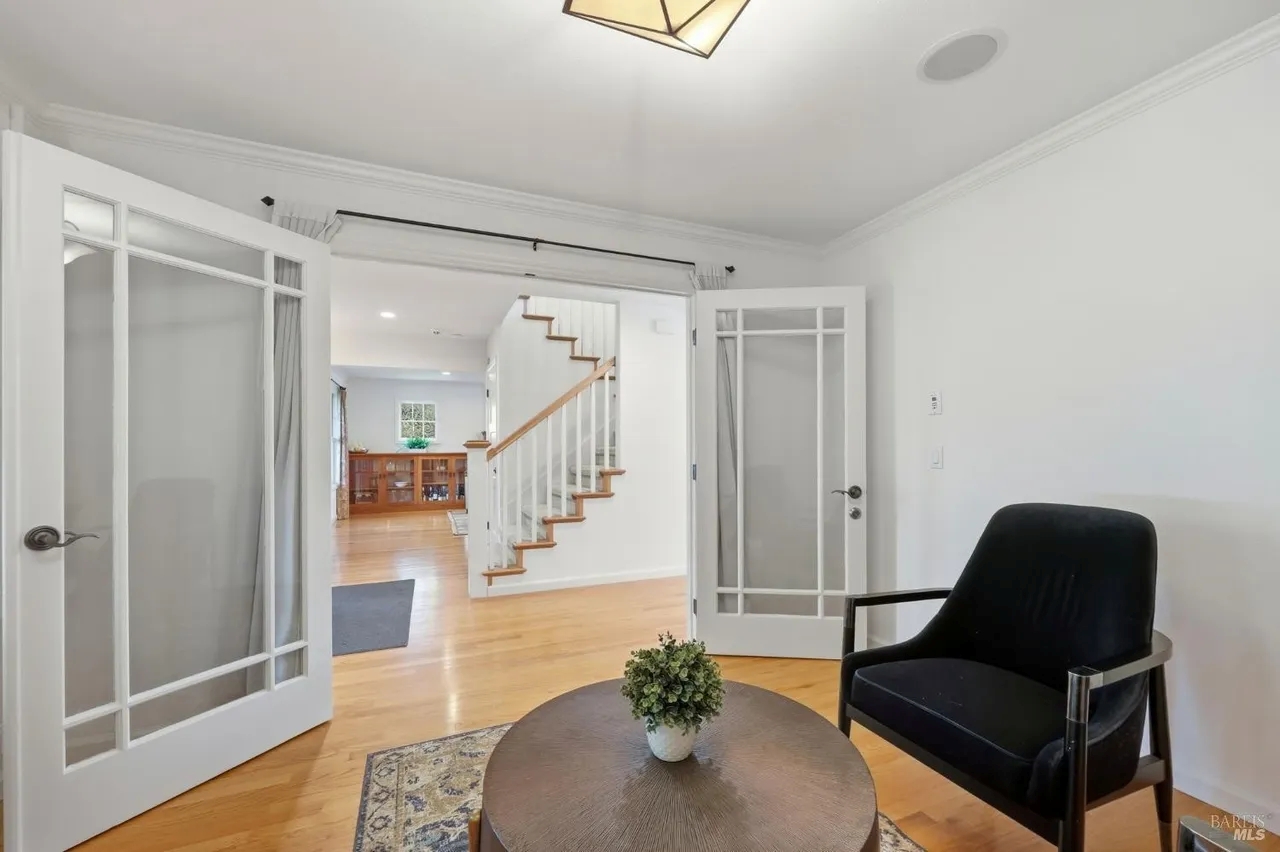 Bright sitting area with French doors and warm hardwood floors