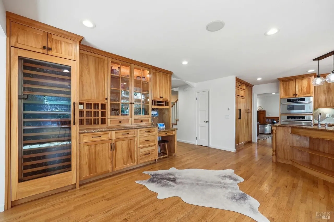 Spacious gourmet kitchen with custom wood cabinetry and wine fridge