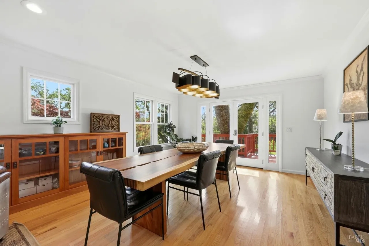 Bright dining room with French doors opening to a scenic private deck