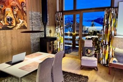 Dining and living area with floor-to-ceiling windows onto the mountains