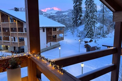 Snow-covered chalets and mountains seen from the balcony