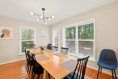 This bright dining room is framed by large windows overlooking leafy views, turning every meal into a front-row seat to the surrounding forest.