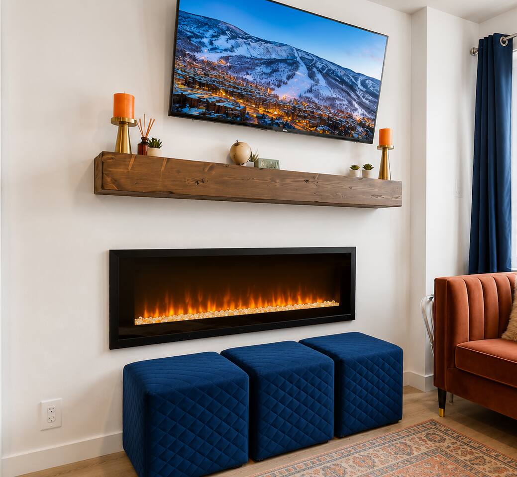 Cozy modern lounge with fireplace, TV, and stylish accent seating