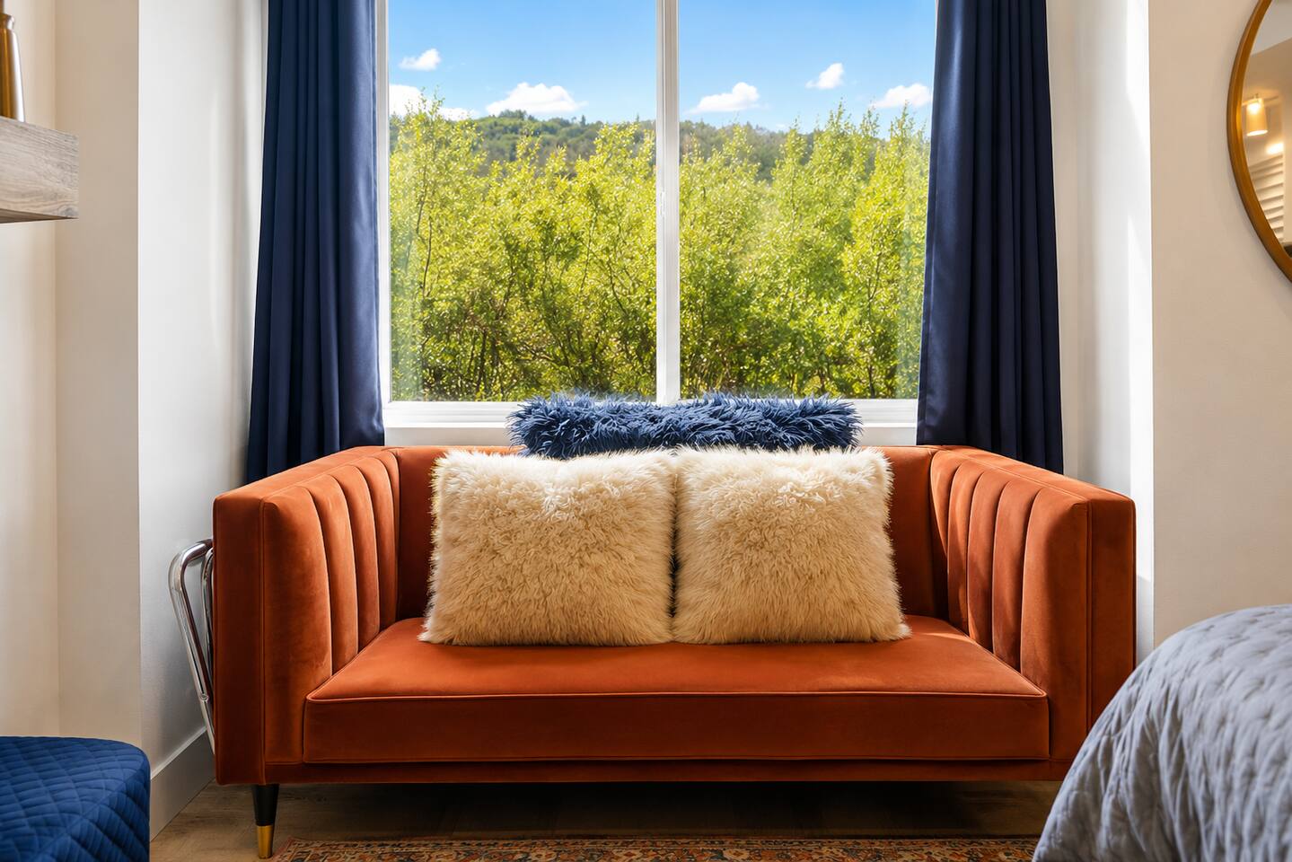 Cozy velvet loveseat with lush window views and natural light