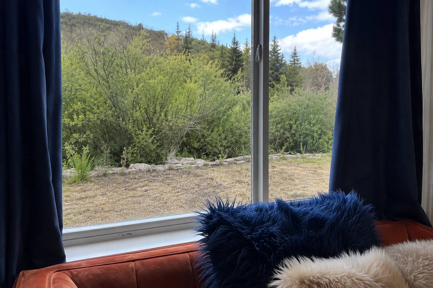 Cozy window nook with serene garden and hillside views