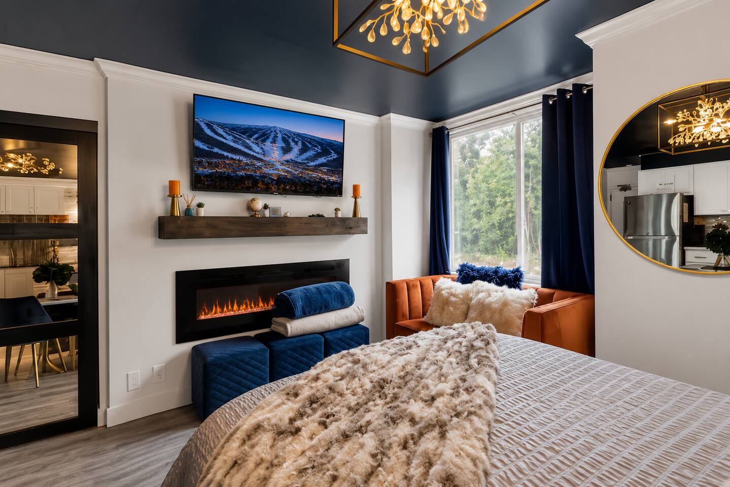 Cozy luxe bedroom with fireplace, TV, and elegant designer touches