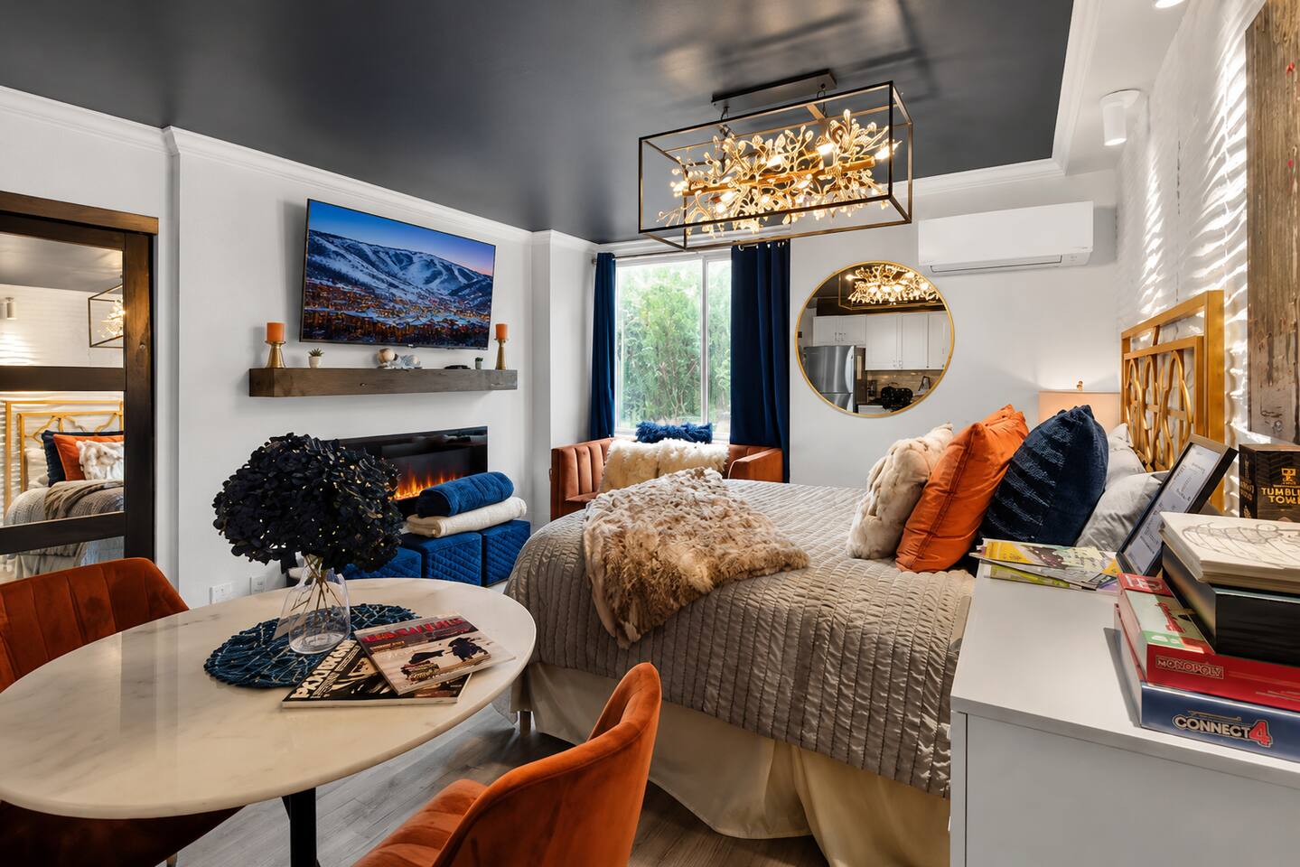 Chic, cozy bedroom with luxe touches, TV, AC, and elegant chandelier
