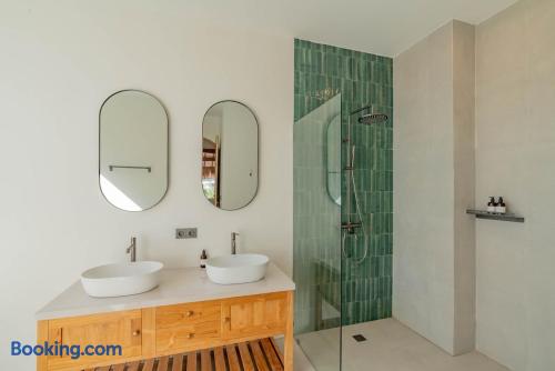 Spa-like bathroom with double vanity and stylish green-tile rain shower